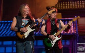 Two pop stars of a rock band performing on the stage